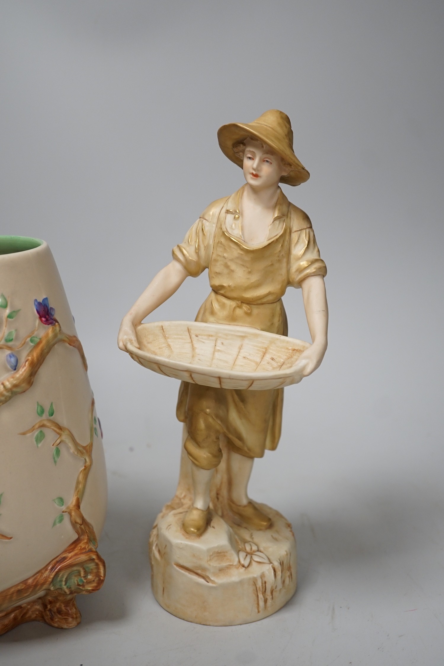A Royal Dux figure of a water carrier and a Clarice Cliff for Newport Pottery vase. Tallest 27cm